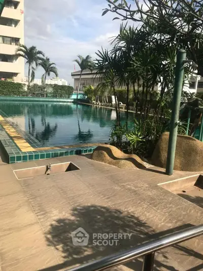 Luxurious poolside view with lush greenery and modern architecture, perfect for relaxation and leisure.