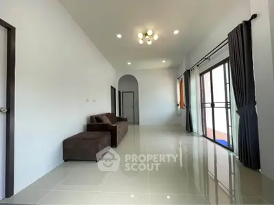 Spacious living room with modern lighting and large windows for natural light.