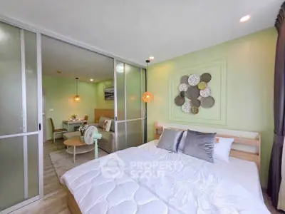 Modern bedroom with sliding glass doors and stylish decor in a cozy apartment.