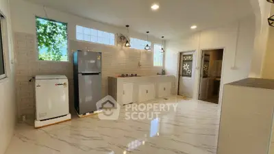 Modern kitchen with sleek appliances and stylish lighting in a bright, spacious layout.