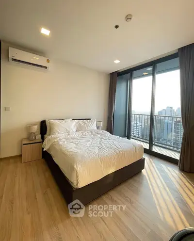Spacious bedroom with city view and large windows in modern apartment