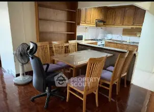 Spacious dining area with wooden furniture and open kitchen layout, ideal for family gatherings.