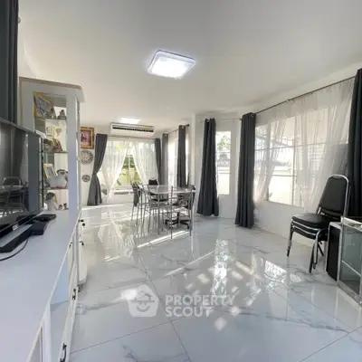 Bright and spacious living room with modern decor and large windows.