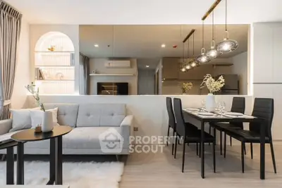 Modern living room with stylish decor and dining area, featuring elegant lighting and cozy ambiance.