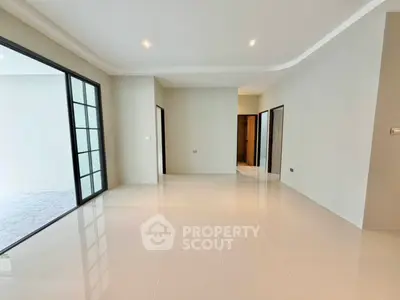 Spacious modern living room with sleek tile flooring and large windows for natural light.