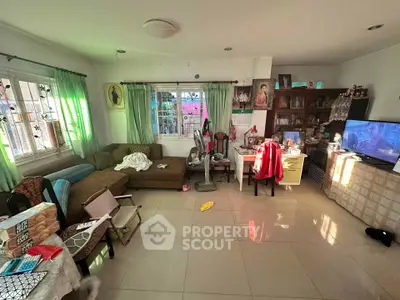 Spacious living room with natural light, cozy seating, and modern decor.
