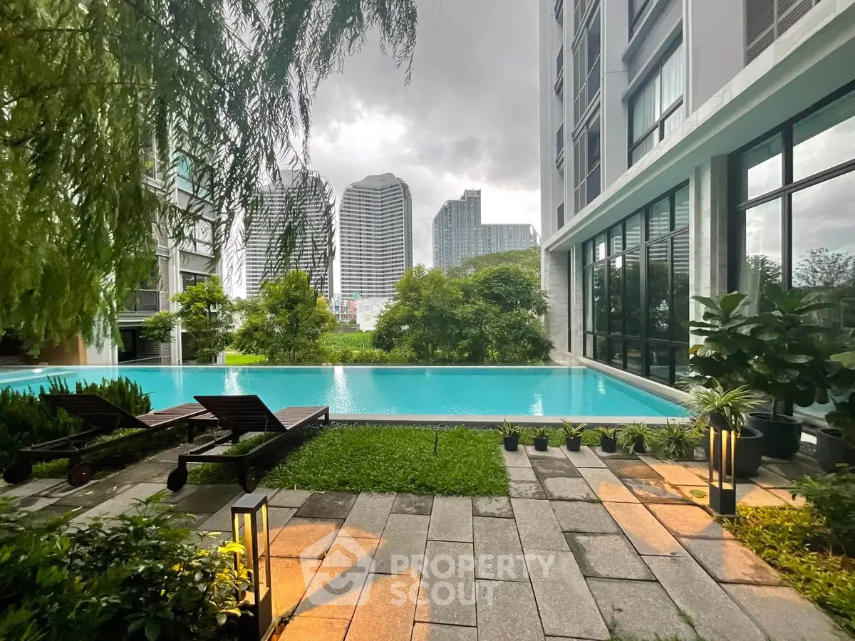 Luxurious condominium pool area with city skyline view, lush greenery, and modern architecture.