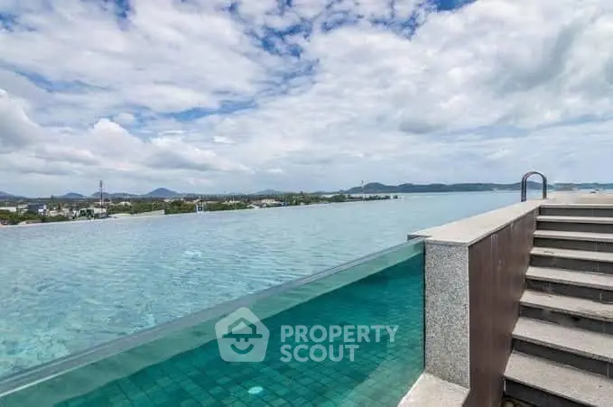 Stunning rooftop infinity pool with panoramic ocean view and clear blue skies.