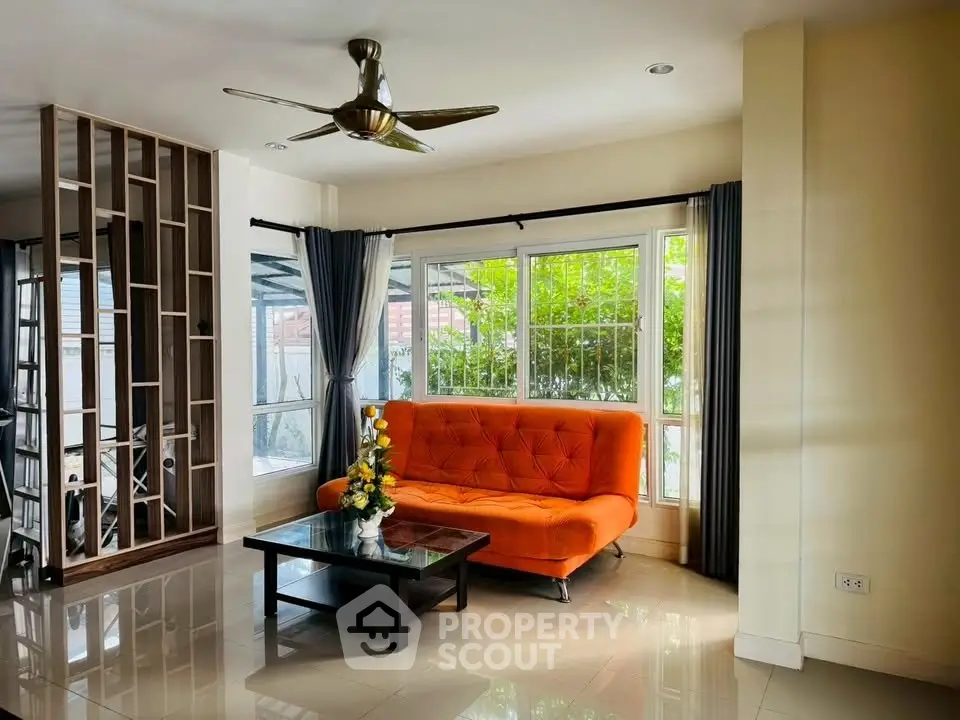 Bright living room with orange sofa and large windows, modern decor