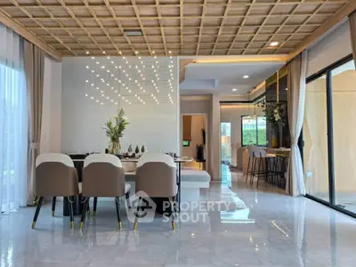 Luxurious open-plan living and dining area with modern decor and elegant lighting.