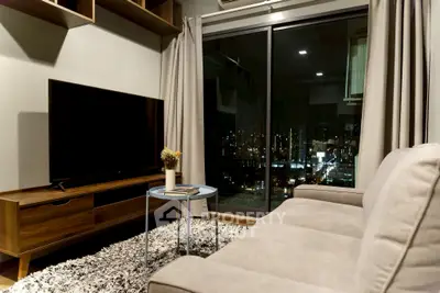 Modern living room with city view, cozy sofa, and large TV, perfect for urban living.