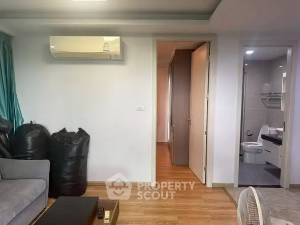 Modern living room with air conditioning and view into bathroom