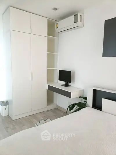 Modern minimalist bedroom with built-in wardrobe and air conditioning unit.