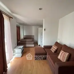 Spacious living area with cozy brown sofa and natural light