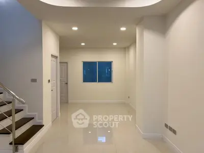 Spacious interior with modern staircase and ample lighting, perfect for customization.