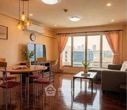 Spacious living room with large windows and city view, featuring modern furniture and elegant lighting.