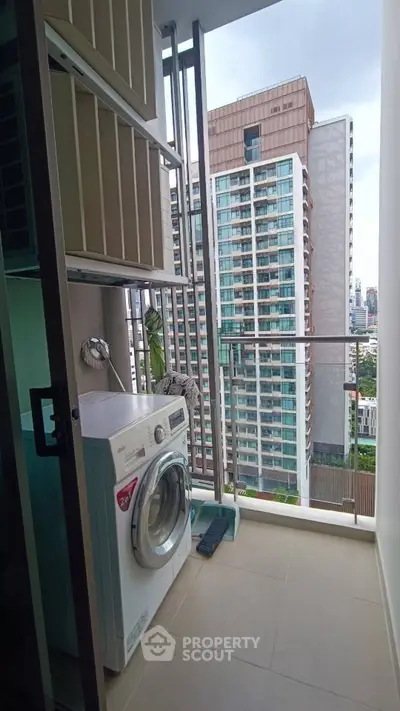 Modern high-rise balcony with washing machine and city view