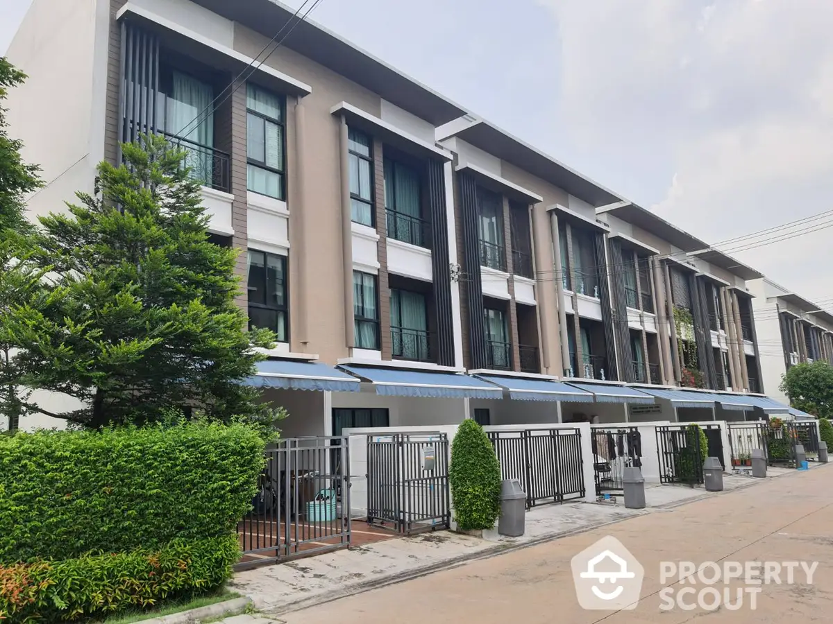 Modern townhouses with sleek design, large windows, and private balconies, nestled in a serene neighborhood with lush greenery.