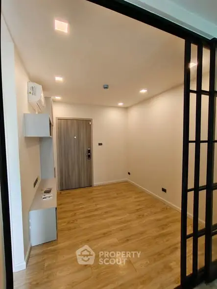 Modern minimalist room with wooden flooring and recessed lighting