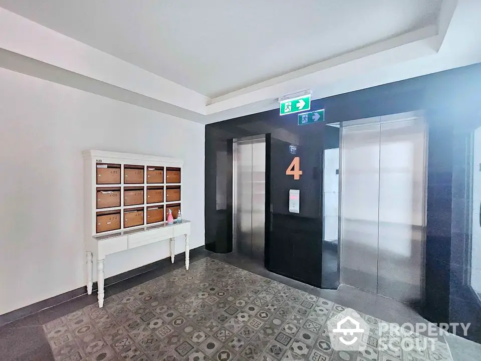 Modern apartment building elevator lobby with stylish floor tiles and mailboxes.