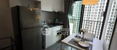 Modern kitchen with dining area and balcony view in high-rise apartment