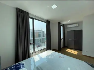 Bright bedroom with large windows and modern decor in a stylish apartment.
