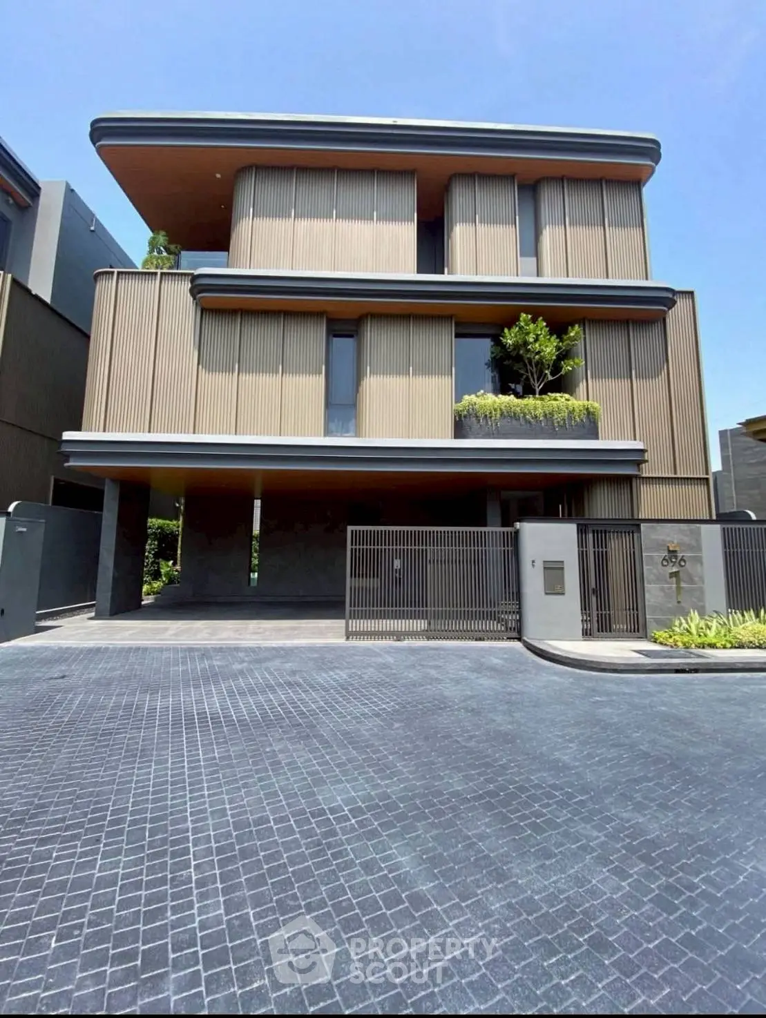 Modern three-story building with sleek design and gated entrance
