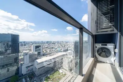 Stunning high-rise balcony with panoramic city view and modern washing machine.
