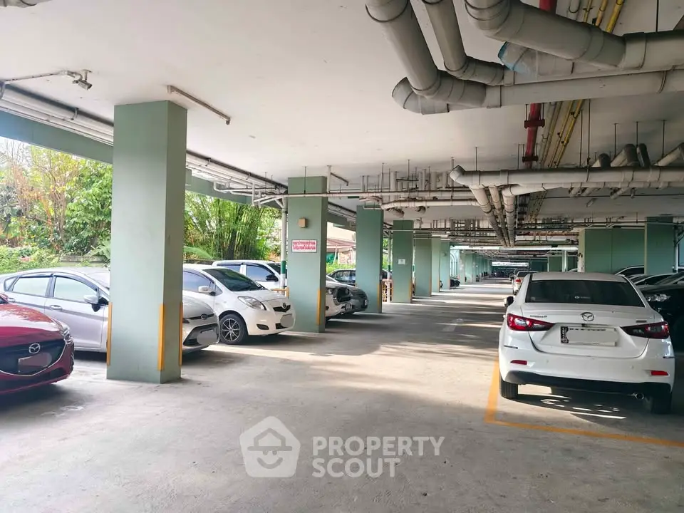 Spacious covered parking area with multiple cars in a residential building.