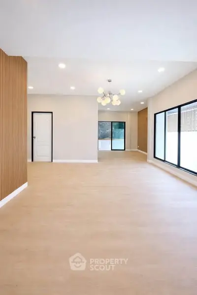 Spacious modern living room with elegant lighting and large windows for natural light.