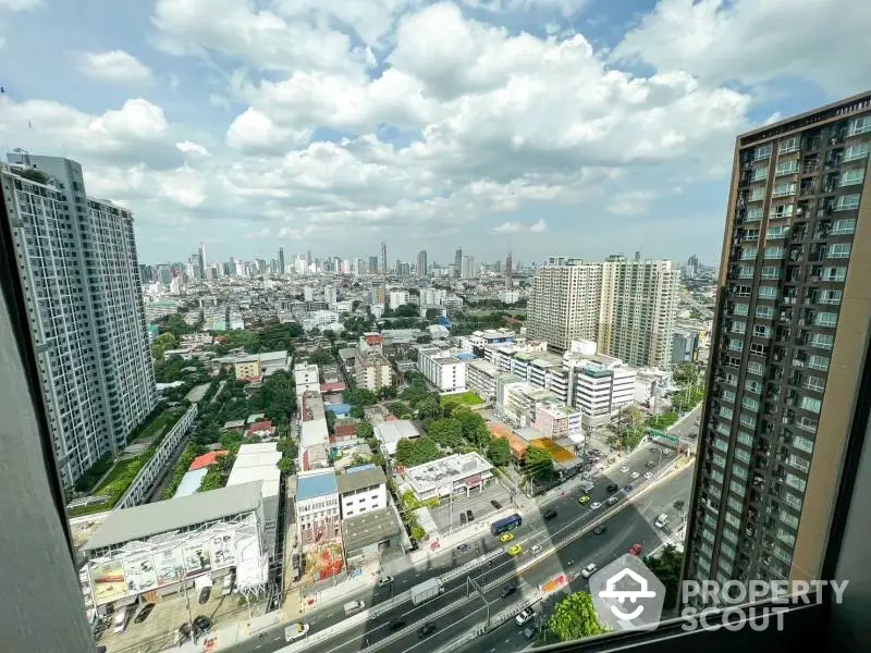 Stunning cityscape view from high-rise apartment with expansive skyline and bustling streets below.