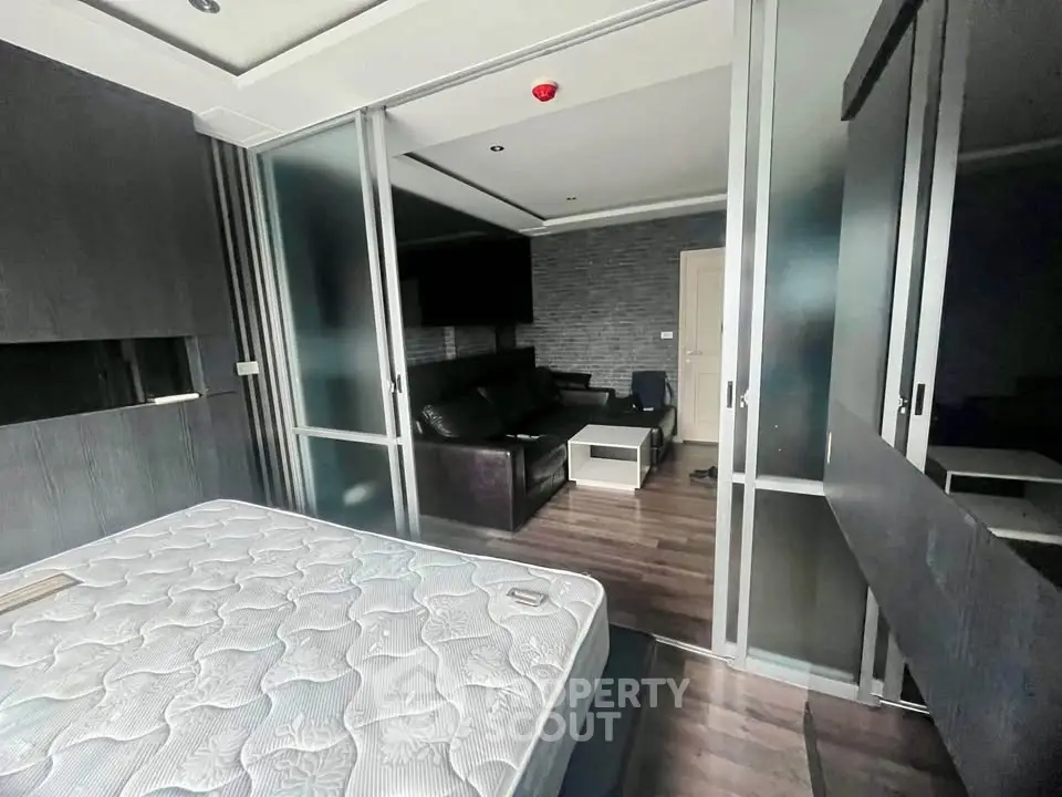 Modern bedroom with sliding glass doors and sleek dark furniture