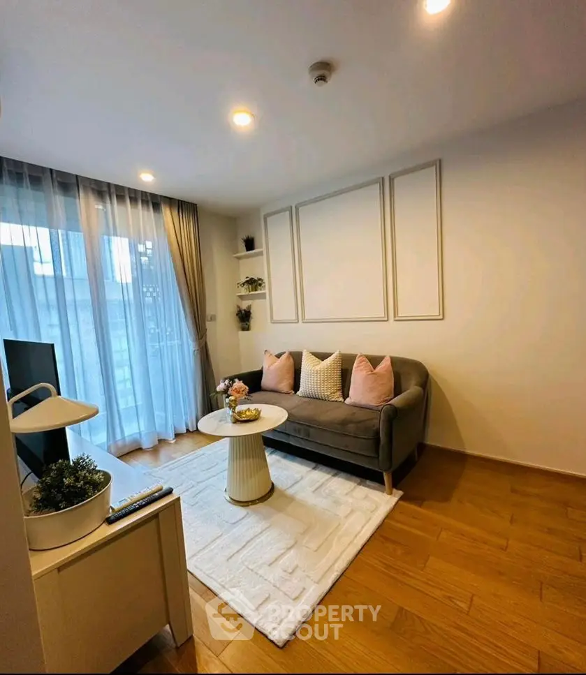 Chic modern living room with cozy sofa, stylish decor, and natural light from large windows.