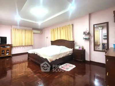Spacious bedroom with elegant wooden flooring and classic furniture