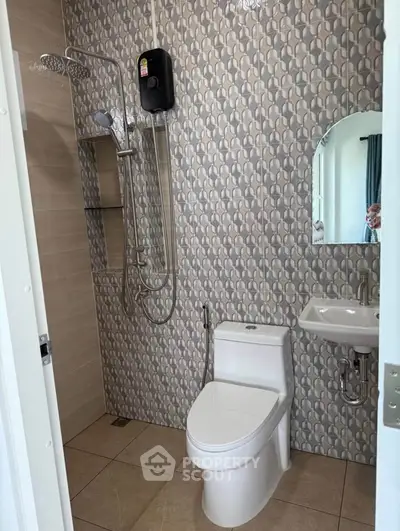 Modern bathroom with stylish tiles, shower, and compact sink in a contemporary home.