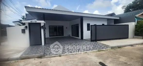 Modern single-story house with spacious driveway and sleek design.