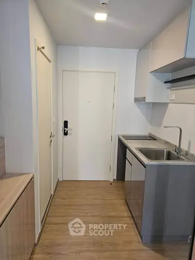 Modern compact kitchen with sleek cabinetry and wood flooring