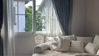 Cozy bedroom with plush pillows and natural light through large window