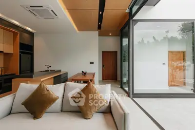 Modern open-plan living room with sleek kitchen and large glass doors