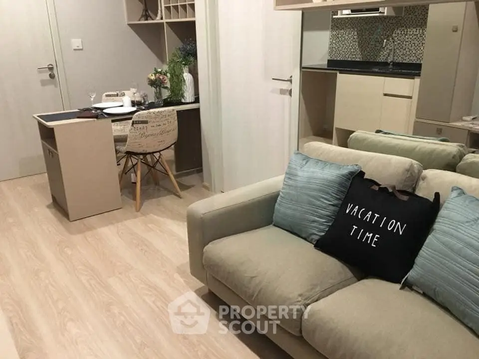 Modern living room with cozy sofa and stylish dining area in open-plan apartment.