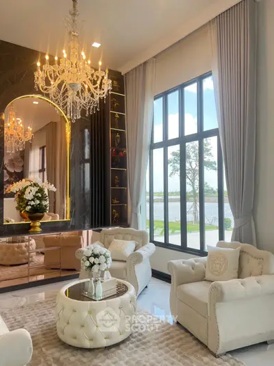 Luxurious living room with elegant chandelier and large windows offering stunning water views.