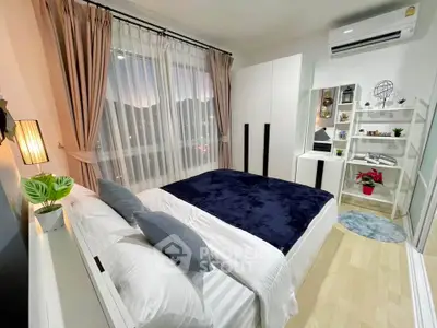 Modern bedroom with stylish decor, large window, and cozy bedding in a contemporary apartment.