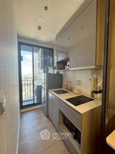 Modern compact kitchen with sleek cabinetry and balcony view