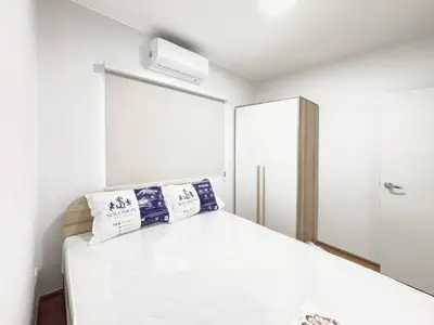 Modern bedroom with air conditioning and sleek wardrobe in a minimalist design.