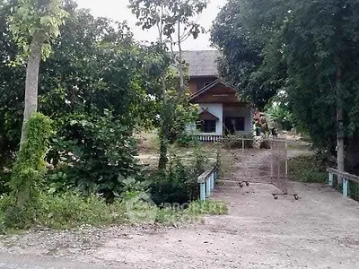 Charming rural house surrounded by lush greenery and trees, offering serene countryside living.