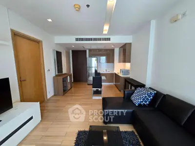 Modern open-layout living room with sleek kitchen and stylish furniture in a contemporary apartment.