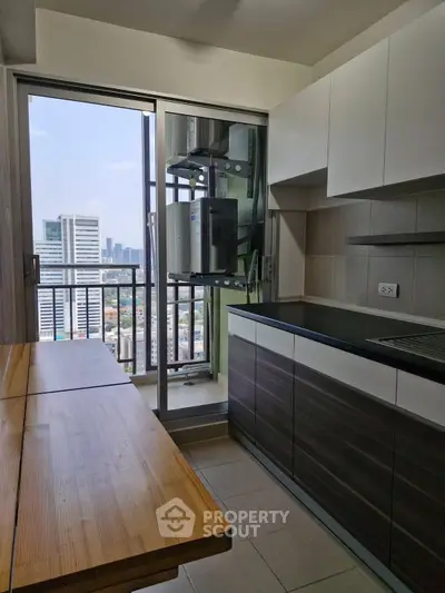 Modern kitchen with city view and sleek cabinetry in high-rise apartment