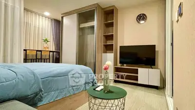 Modern bedroom with cozy decor, featuring a stylish TV setup and elegant furnishings.