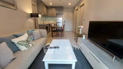 Modern living room with cozy sofa, stylish decor, and open kitchen layout in a contemporary apartment.
