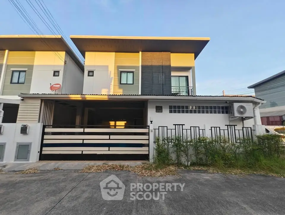 Modern two-story townhouse with sleek design and spacious driveway in a suburban neighborhood.